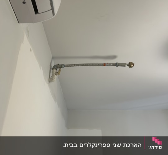 צינור מתכת מחובר לקיר עם חיבורי גז